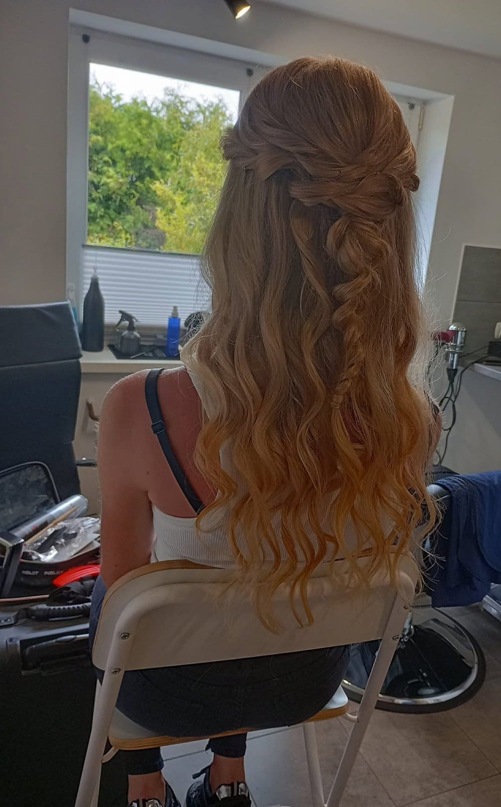 Rozpuszczone, miedziano-blond loki z warkoczową plecionką z tyłu głowy